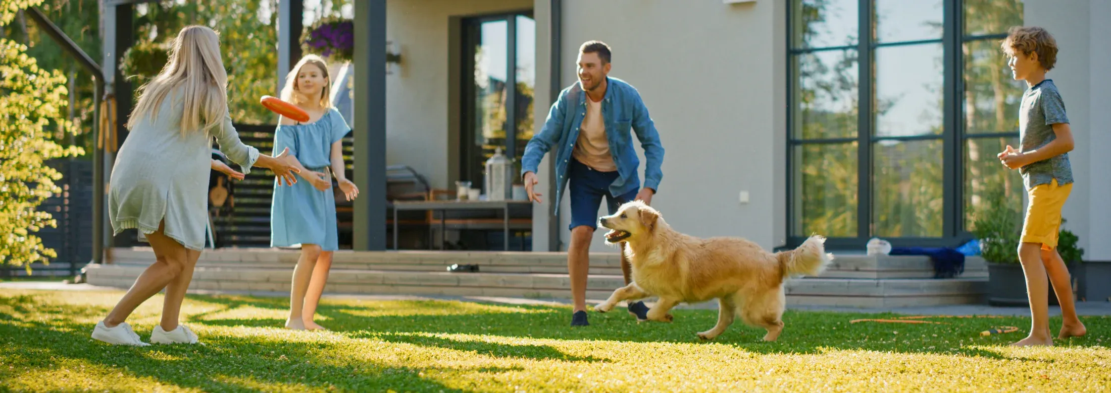 family playing with dog outside